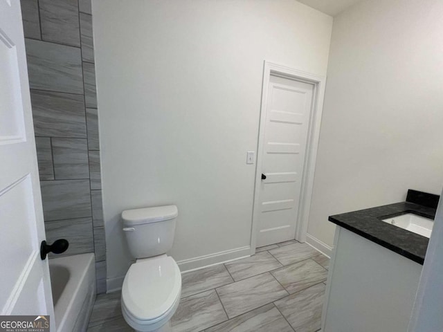 bathroom with vanity, toilet, and a tub to relax in