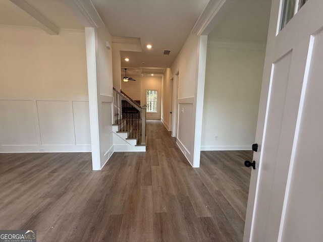 corridor with dark hardwood / wood-style flooring and ornamental molding