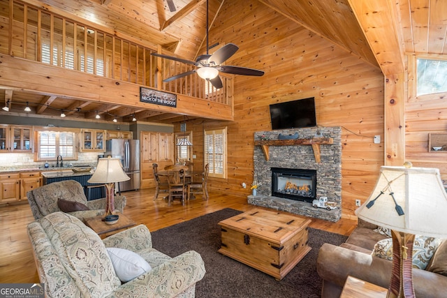 living room featuring wooden walls, high vaulted ceiling, and a wealth of natural light