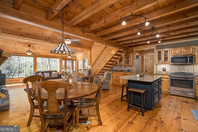 dining area with beamed ceiling, wooden walls, light hardwood / wood-style floors, and wooden ceiling