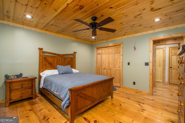 bedroom with ceiling fan, a closet, light hardwood / wood-style floors, and wooden ceiling