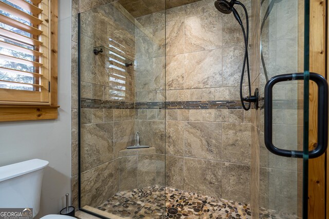 bathroom with an enclosed shower and toilet