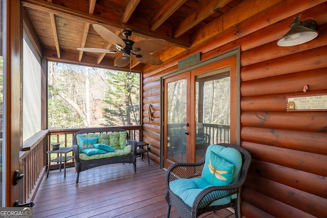 sunroom with beamed ceiling, ceiling fan, and wood ceiling