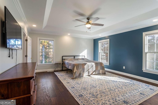 bedroom with dark hardwood / wood-style flooring, a tray ceiling, ceiling fan, and crown molding