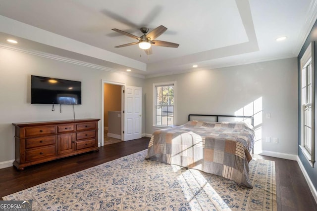 bedroom featuring a tray ceiling, ceiling fan, dark hardwood / wood-style flooring, and crown molding