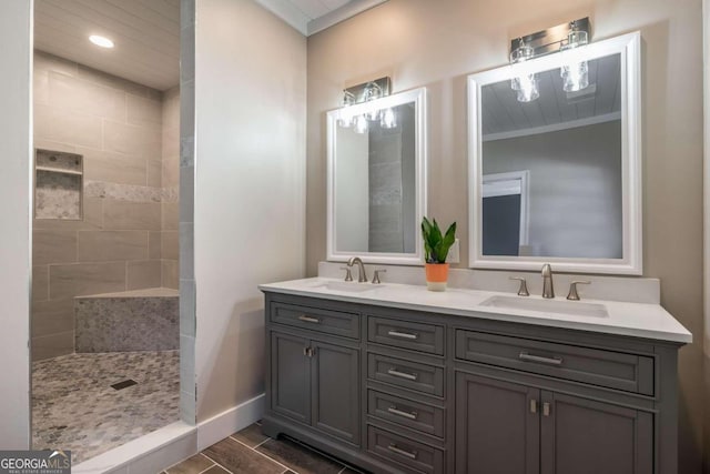 bathroom featuring a tile shower, vanity, and ornamental molding