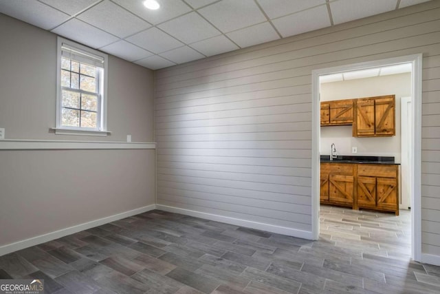 interior space with a paneled ceiling, dark hardwood / wood-style flooring, and sink