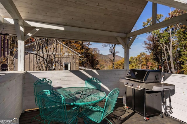 wooden terrace with a mountain view and area for grilling