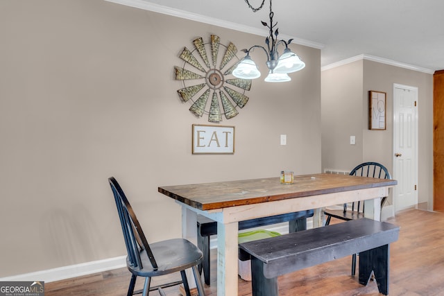 dining room featuring an inviting chandelier, crown molding, and light hardwood / wood-style flooring