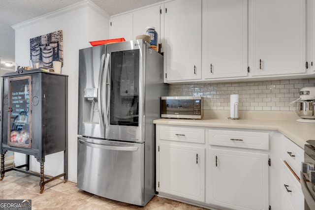 kitchen with backsplash, ornamental molding, a textured ceiling, stainless steel appliances, and white cabinets