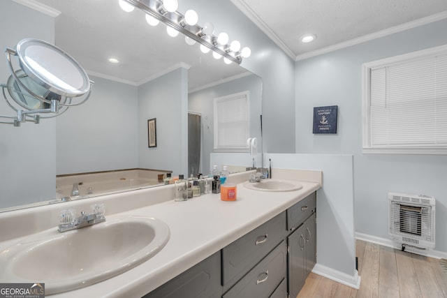 bathroom featuring heating unit, hardwood / wood-style floors, vanity, a shower with shower door, and ornamental molding