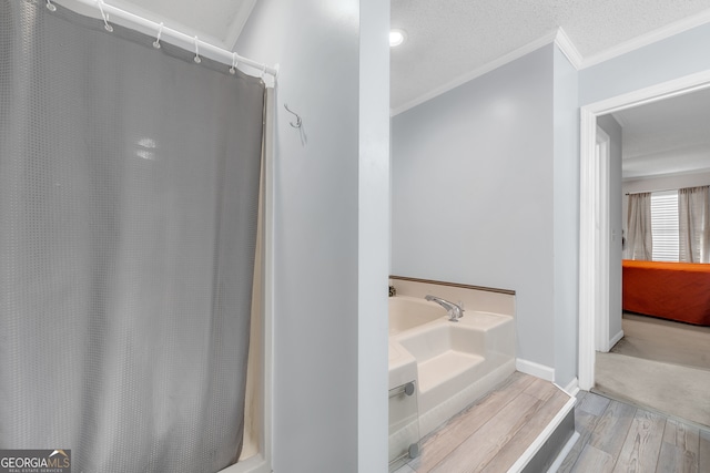 bathroom featuring a bath, crown molding, wood-type flooring, and a textured ceiling