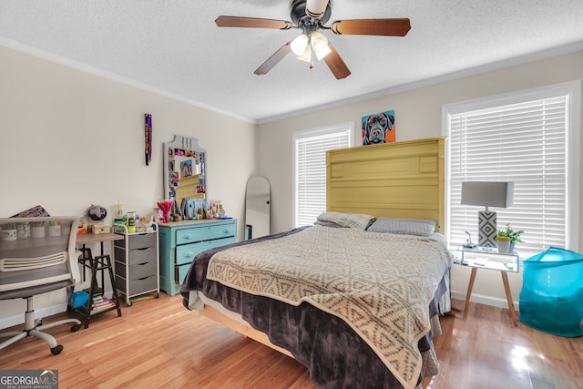 bedroom featuring hardwood / wood-style flooring, ceiling fan, ornamental molding, and a textured ceiling