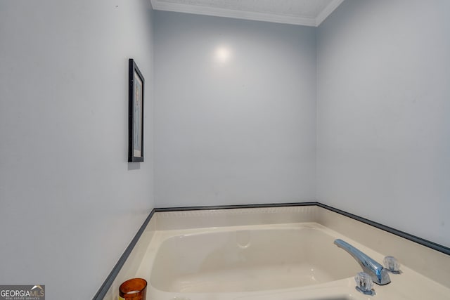 bathroom featuring a textured ceiling, crown molding, and a tub