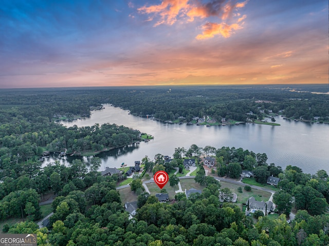 aerial view at dusk featuring a water view