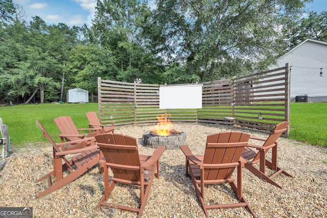 view of patio featuring a storage unit, central AC unit, and an outdoor fire pit