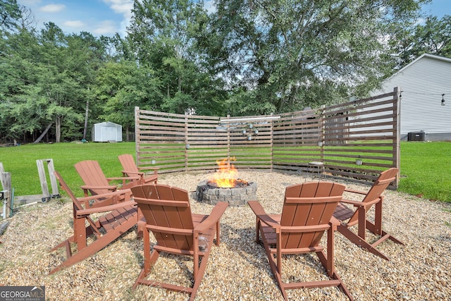 view of patio / terrace featuring a fire pit, a storage unit, and central AC unit