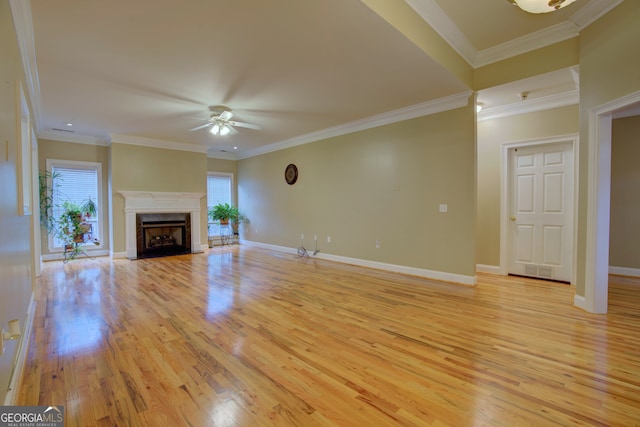 unfurnished living room with light hardwood / wood-style floors, ceiling fan, and crown molding