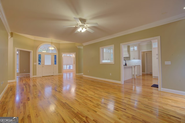 unfurnished living room with ceiling fan, light wood-type flooring, and ornamental molding