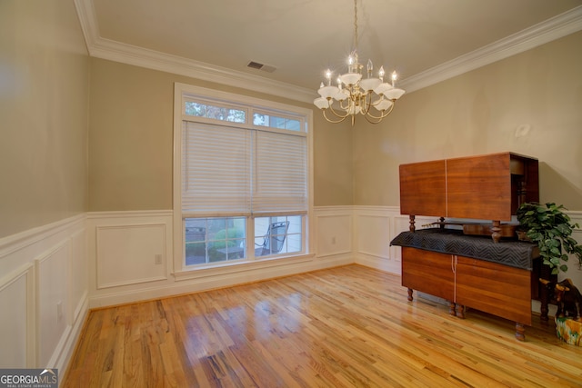 interior space with a chandelier, light hardwood / wood-style floors, and crown molding