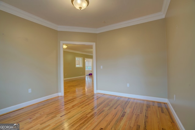 empty room featuring crown molding and light hardwood / wood-style flooring