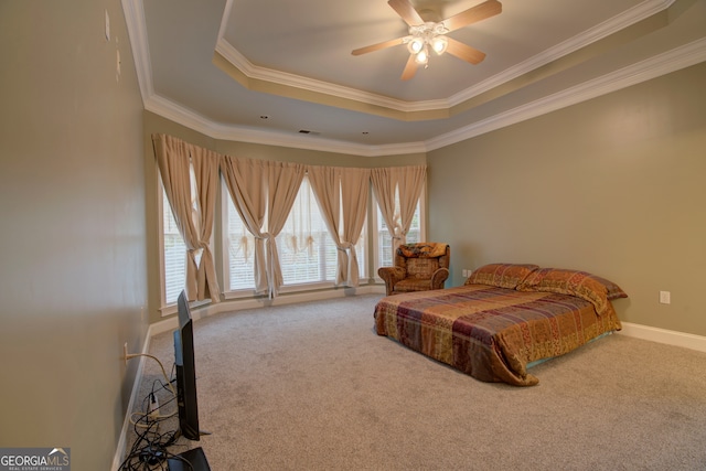 carpeted bedroom featuring ceiling fan, ornamental molding, and a tray ceiling