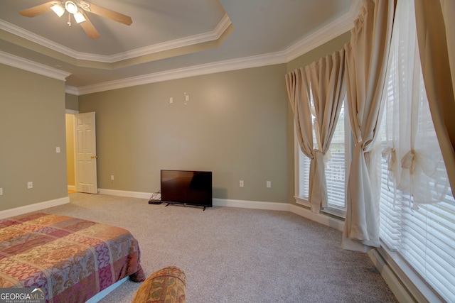 carpeted bedroom with a tray ceiling, ceiling fan, and crown molding