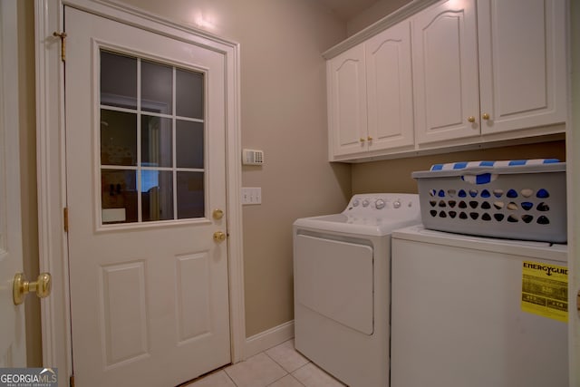 washroom featuring cabinets, light tile patterned floors, and washing machine and clothes dryer