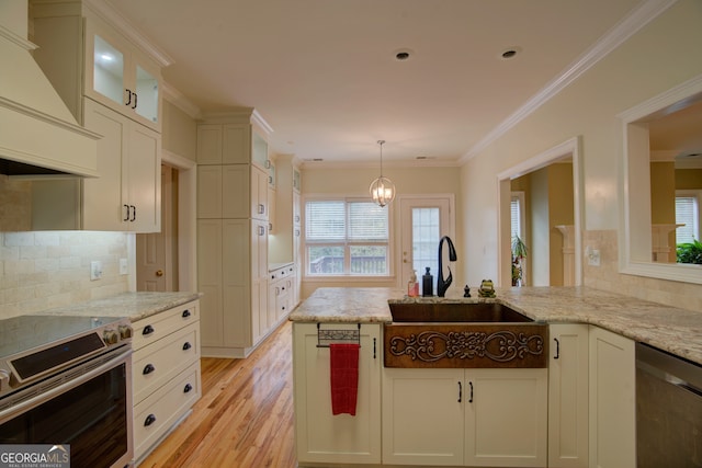 kitchen with light stone counters, sink, light hardwood / wood-style flooring, and appliances with stainless steel finishes