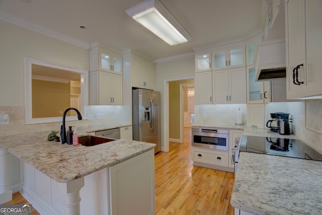 kitchen with kitchen peninsula, backsplash, stainless steel appliances, and white cabinetry