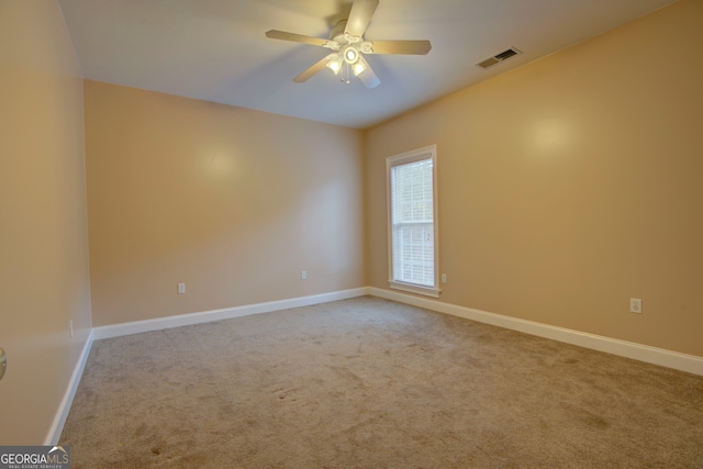 carpeted spare room featuring ceiling fan