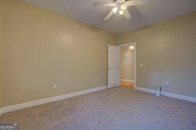 carpeted spare room featuring ceiling fan