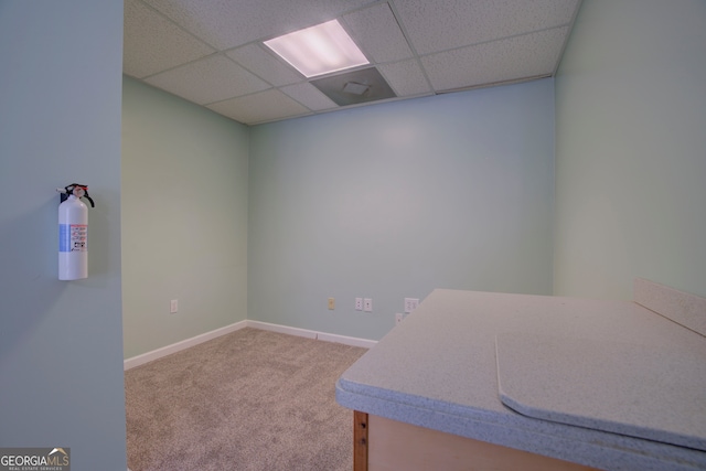 unfurnished office featuring carpet floors and a drop ceiling