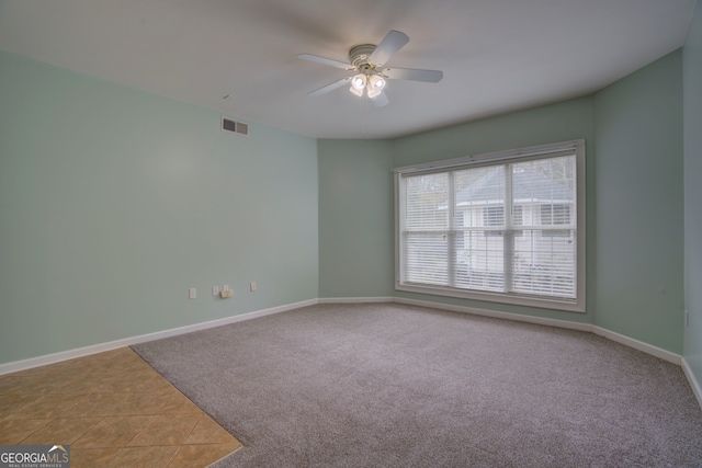 empty room with ceiling fan and carpet