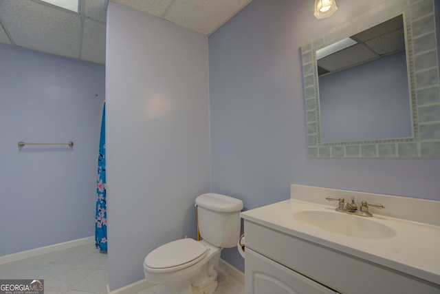 bathroom featuring vanity, a paneled ceiling, toilet, and tile patterned flooring