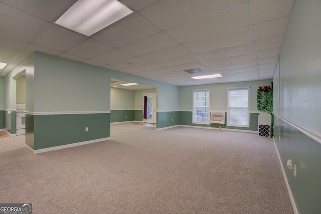 empty room featuring a drop ceiling and light colored carpet