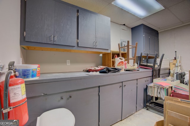 kitchen featuring gray cabinets and a drop ceiling