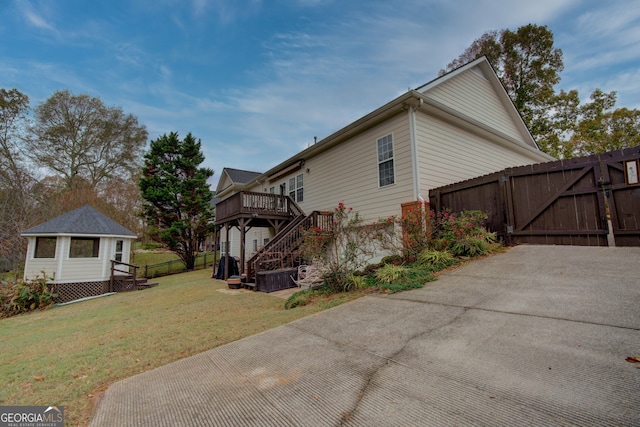 view of side of property with a lawn and a deck