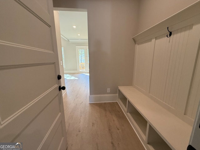 mudroom featuring light wood-type flooring and crown molding