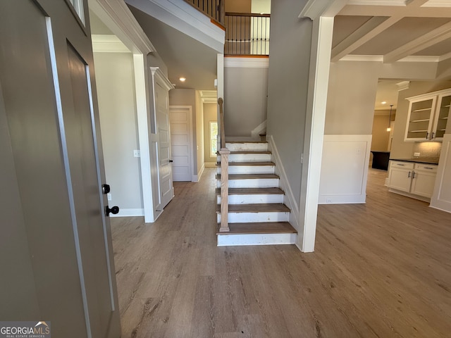 staircase with hardwood / wood-style flooring and beamed ceiling