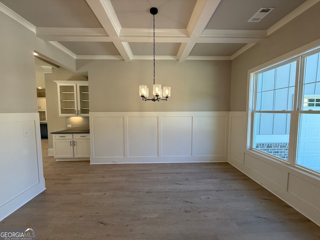 unfurnished dining area featuring beamed ceiling, light wood-type flooring, and coffered ceiling