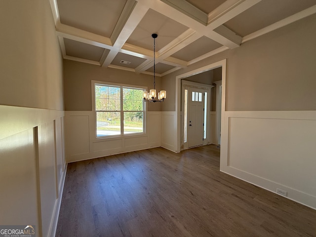 unfurnished dining area featuring hardwood / wood-style floors, an inviting chandelier, beamed ceiling, and coffered ceiling