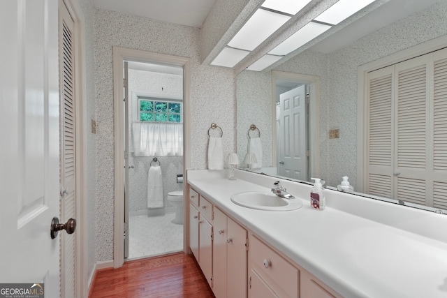 bathroom featuring hardwood / wood-style floors, vanity, and toilet