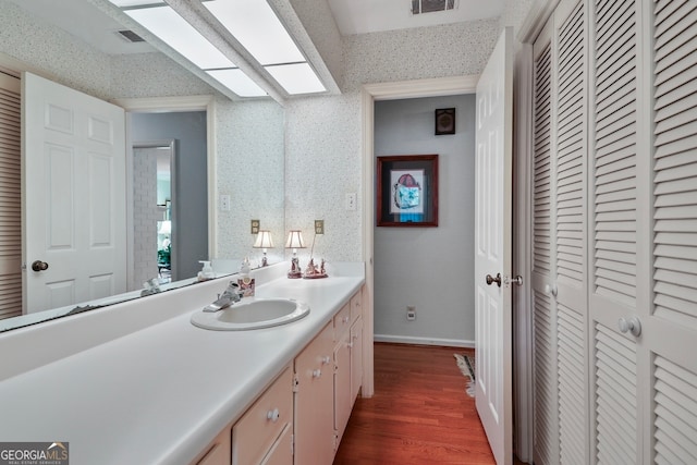 bathroom with vanity, wood-type flooring, and a textured ceiling