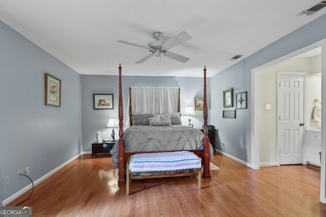 bedroom featuring light hardwood / wood-style floors, ceiling fan, and ensuite bathroom