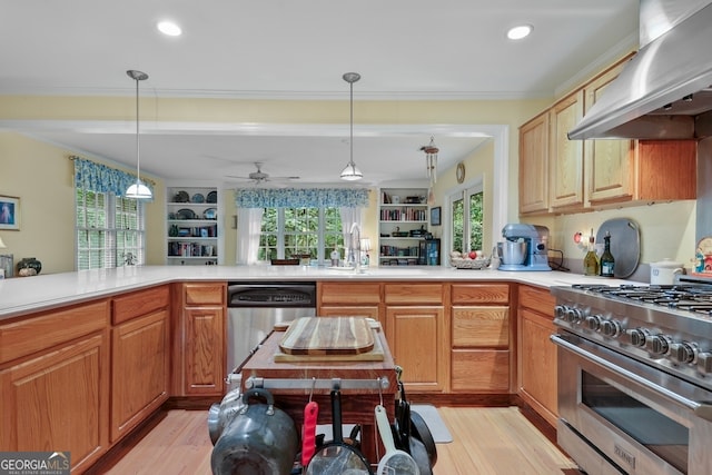 kitchen featuring light hardwood / wood-style floors, pendant lighting, extractor fan, and appliances with stainless steel finishes