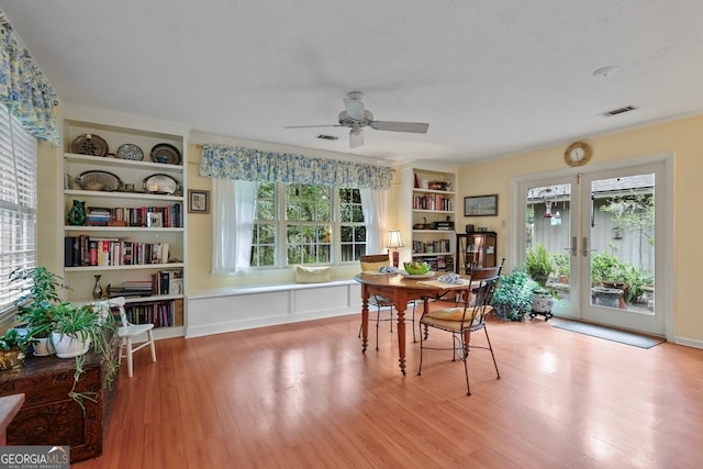 interior space featuring ceiling fan, light hardwood / wood-style floors, built in features, and a textured ceiling