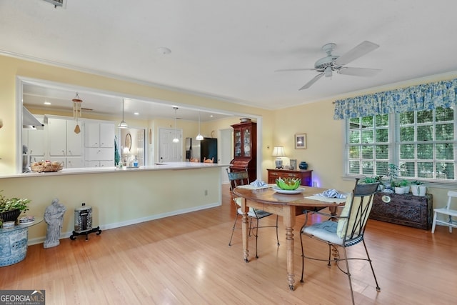 dining space with ceiling fan, ornamental molding, and light hardwood / wood-style flooring