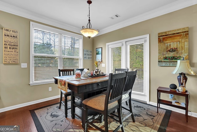 dining space featuring plenty of natural light, crown molding, and dark wood-type flooring