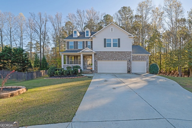 front facade featuring covered porch, a garage, and a front yard